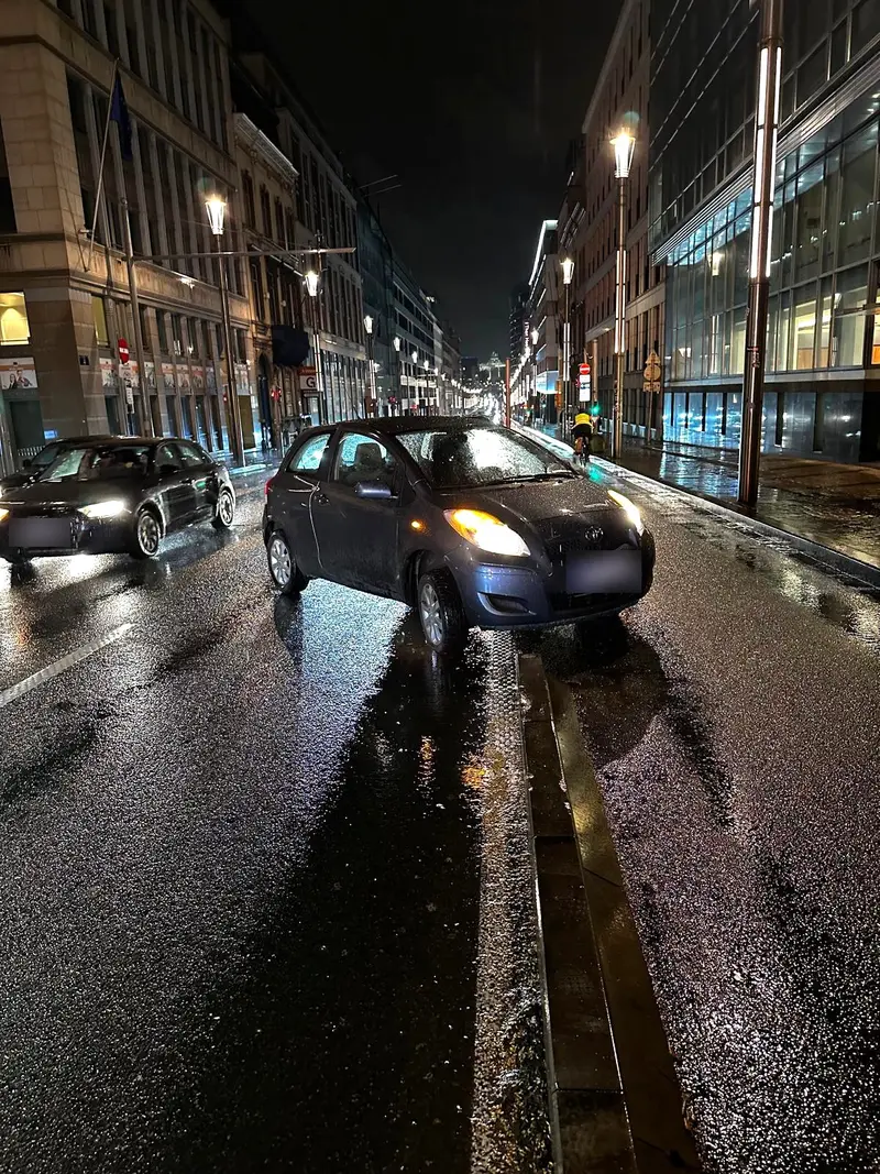 Toyota bloquée sur la bordure de la piste cyclable rue de la Loi à Bruxelles, de nuit, avant le dépannage