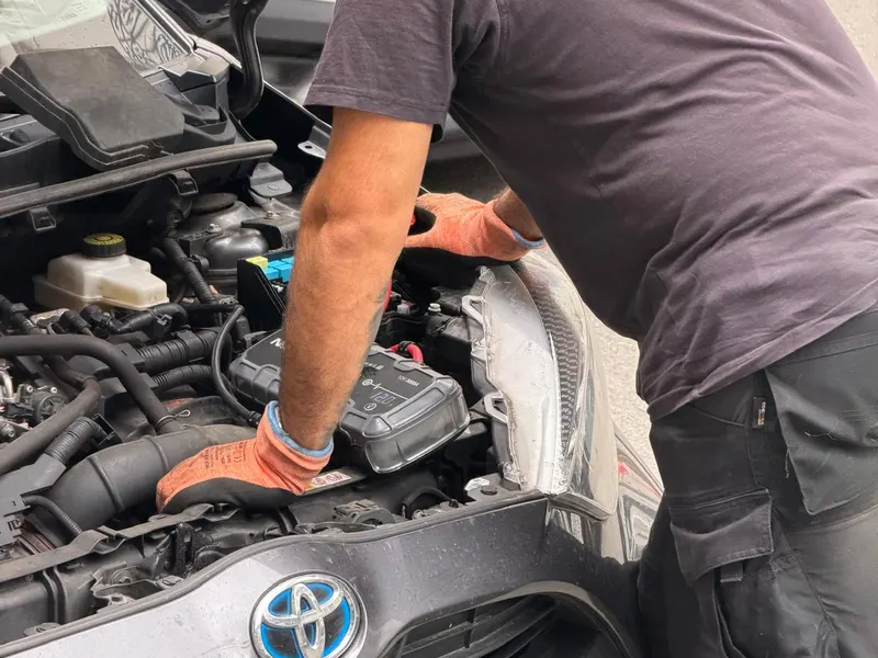 Dépanneur BCD qui branche un booster sur la batterie d'une Toyota hybride à Bruxelles